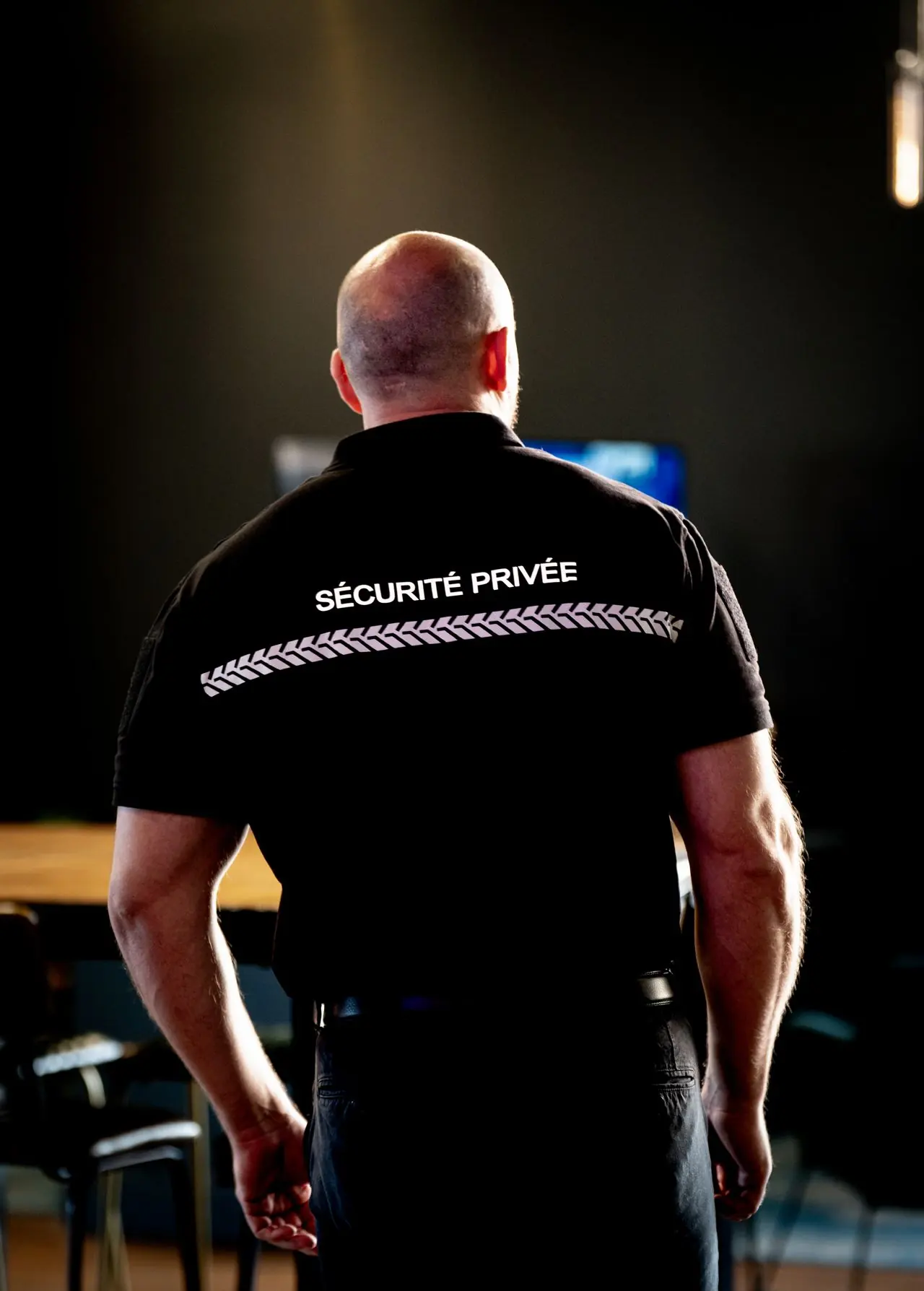Agent NOX SECURITY de dos en surveillance dans un établissement (photo d’illustration)